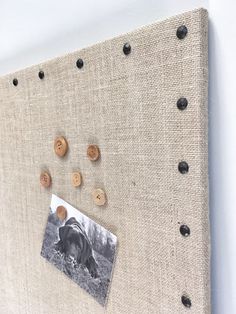 a canvas board with buttons on it and a photo pinned to the back of it