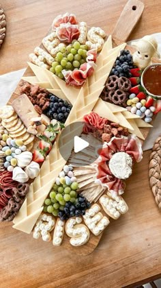 a wooden table topped with lots of different types of cheese and crackers on top of it