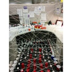 an office cubicle filled with lots of bottles and cans