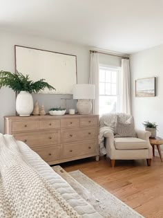 a living room with a couch, chair and dresser