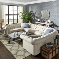 a living room filled with furniture and a large mirror on the wall above it's windows