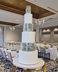 a wedding cake sitting on top of a table in front of a chandelier