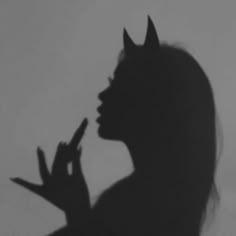 the shadow of a woman with horns on her head