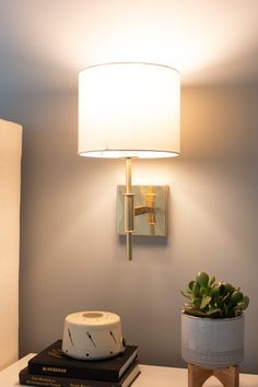 a lamp that is on top of a table next to a potted succulent