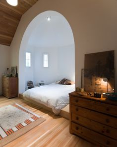 an image of a bedroom with white walls and wood flooring on the phone screen