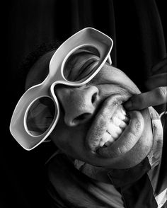 a man with sunglasses on his face and tongue sticking out from under the glasses that he is wearing