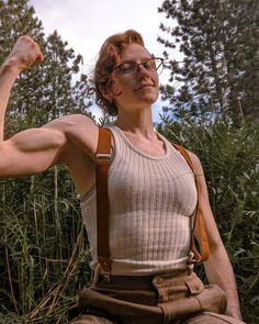 a woman sitting in the grass with her arm raised