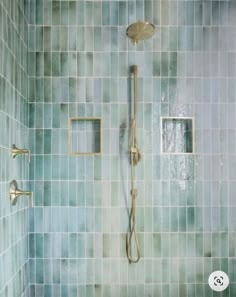 a bathroom with green tiles and gold fixtures