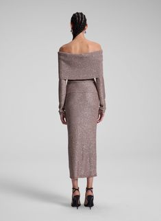 The Evelyn Top is crafted from mauve jersey and embellished with silver sequins. This off-the-shoulder midi silhouette features a second-skin fit, long sleeves, and ribbed detailing, blending sleek shimmer with ease. Shop Tops. Styling Tip: Pair with the coordinated skirt for a minimalist take on holiday shine. Metallic Knit, Shop Tops, Knit Midi Skirt, On Holiday, Knit Midi, Silver Sequin, Off Shoulder Tops, Second Skin, Midi Length