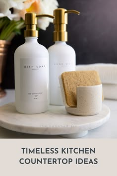 two soap dispensers sitting on top of a white counter next to a sponge