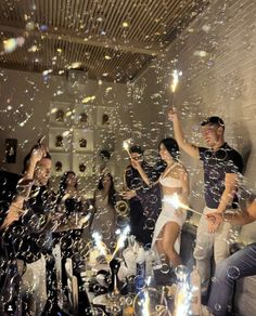 a group of people standing next to each other with bubbles in the air