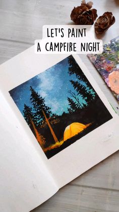 an open book with some pictures and pine cones on the table next to it that says let's paint a campfire night