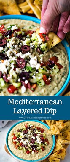 a hand dipping a tortilla chip into a bowl of mediterranean layered dip