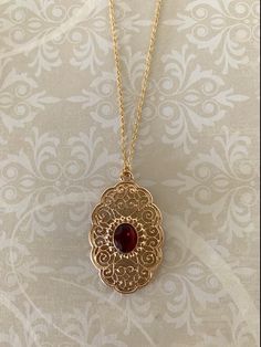 "Striking, lovely and somewhat large open morocco inspired filigree design with scalloped edging gold tone necklace with center oval red stone, red stone jewelry, red stone pendant, large stone necklace, gold filigree, morocco necklace, gold oval necklace, Pendant measures 1 3/4\" L X 1 1/8\" W and is on an 18\" chain. ★ Want to see more?  Please visit my shop at: https://www.etsy.com/shop/DesignsByPeg" Luxury Red Jewelry With Center Stone, Luxury Red Jewelry With Natural Stones, Red Necklace Stone, Luxury Red Pearl Pendant Jewelry, Luxury Red Necklace For Puja, Luxury Red Traditional Jewelry, Luxury Traditional Red Jewelry, Luxury Red Necklace With Polished Finish, Gold Pendant Jewelry Turkish