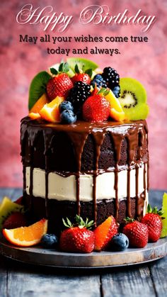 a birthday cake with fresh fruit and chocolate icing on top, sitting on a wooden table