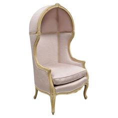 a pink and gold upholstered chair with an oval shaped back, sitting against a white background