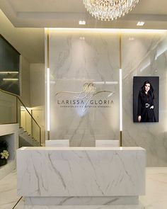 a marble reception desk in front of a chandelier and photo on the wall