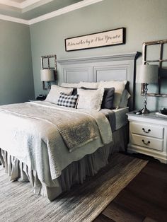 a bedroom with a bed, dressers and two lamps on either side of the bed