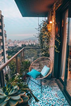 a balcony with a chair, potted plants and a view of the city from it