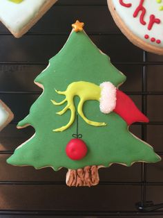 decorated cookies in the shape of a christmas tree and elf's hat on a rack