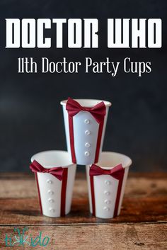 three white cups with red bow ties and the words doctor who 11th doctor party cups