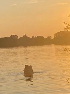 a person swimming in the water at sunset