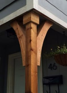 the corner of a house with a potted plant hanging from it's side