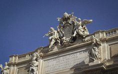 an ornate building with statues on the front and blue sky in the backgroud