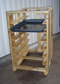 a wooden shelf with a black tray on it's top and stairs to the bottom