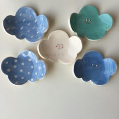 four blue and white plates with clouds painted on the sides, one has a face