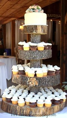 a three tiered cake with cupcakes on it