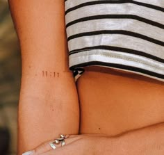 a close up of a person's arm with a small tattoo on the side