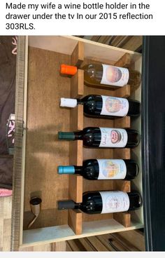 wine bottles are lined up in a wooden holder