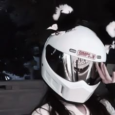 a woman wearing a white helmet with birds on her head