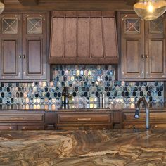 a kitchen with marble counter tops and wooden cabinets, along with an oven hood over the stove