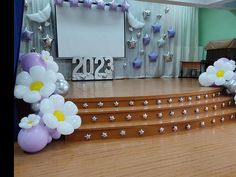 the stage is decorated with balloons and flowers