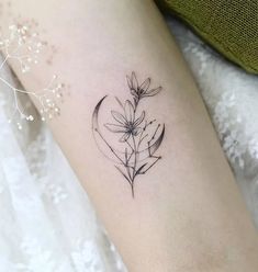 a black and white photo of a flower tattoo on the left thigh, with an arrow in the middle