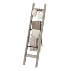 a wooden ladder with towels hanging from it's sides and a hat on top