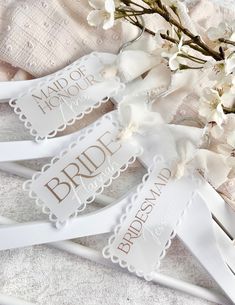 three white bridal hangers with the names of bride and grooms on them