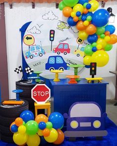 a blue table topped with lots of balloons next to a sign that says stop on it