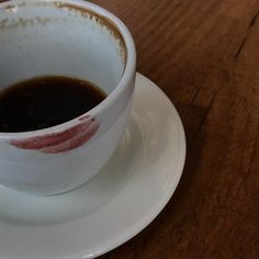 a cup of coffee sitting on top of a white saucer