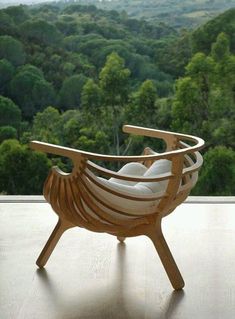 a wooden chair sitting on top of a hard wood floor next to a large window