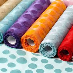 six different colors of polka dot fabric laid out in a row on top of a table