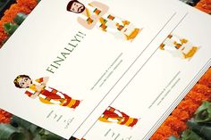 an image of two wedding cards on top of some orange flowers and greenery in the background