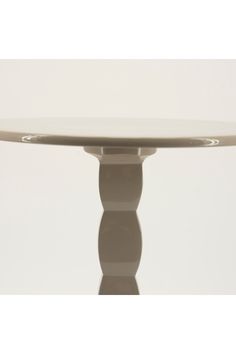 a white table with an oval top and two circular bases on each side, in front of a plain background