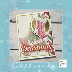 a christmas card with a teddy bear and stocking hanging from it's side