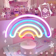 a rainbow shaped light sitting on top of a table next to a box with stuffed animals