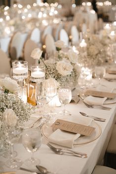 Image shows a white wedding tablescape with lush florals, crystal accents, and place settings. White And Ivory Wedding Table Place Settings, Timeless Wedding Decor Round Table, White Wedding Design, Wedding White Table Setting, Classic White Wedding Theme, Modern Elegant Wedding Theme, White Roses And Babies Breath Wedding, Wedding Styles Themes Modern, Elegant Timeless Wedding Decor