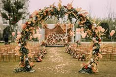 an outdoor ceremony setup with balloons and flowers on the aisle, surrounded by gold chairs