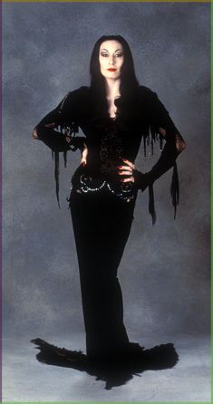 an image of a woman dressed in black with feathers on her head and long sleeves